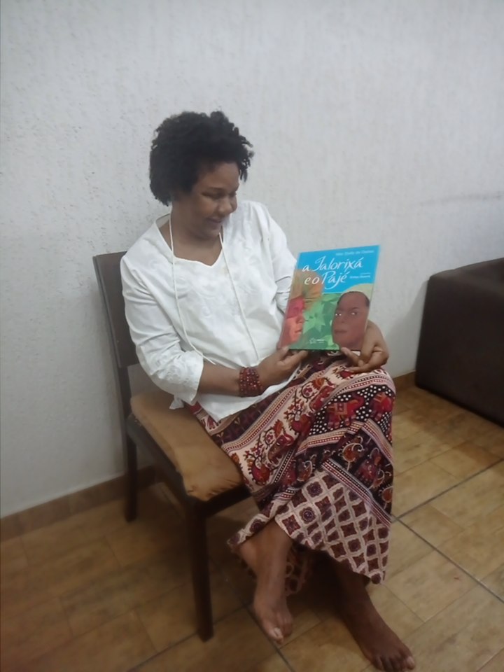 Maria José Limaa com livro de Mãe Stella de Oxossi